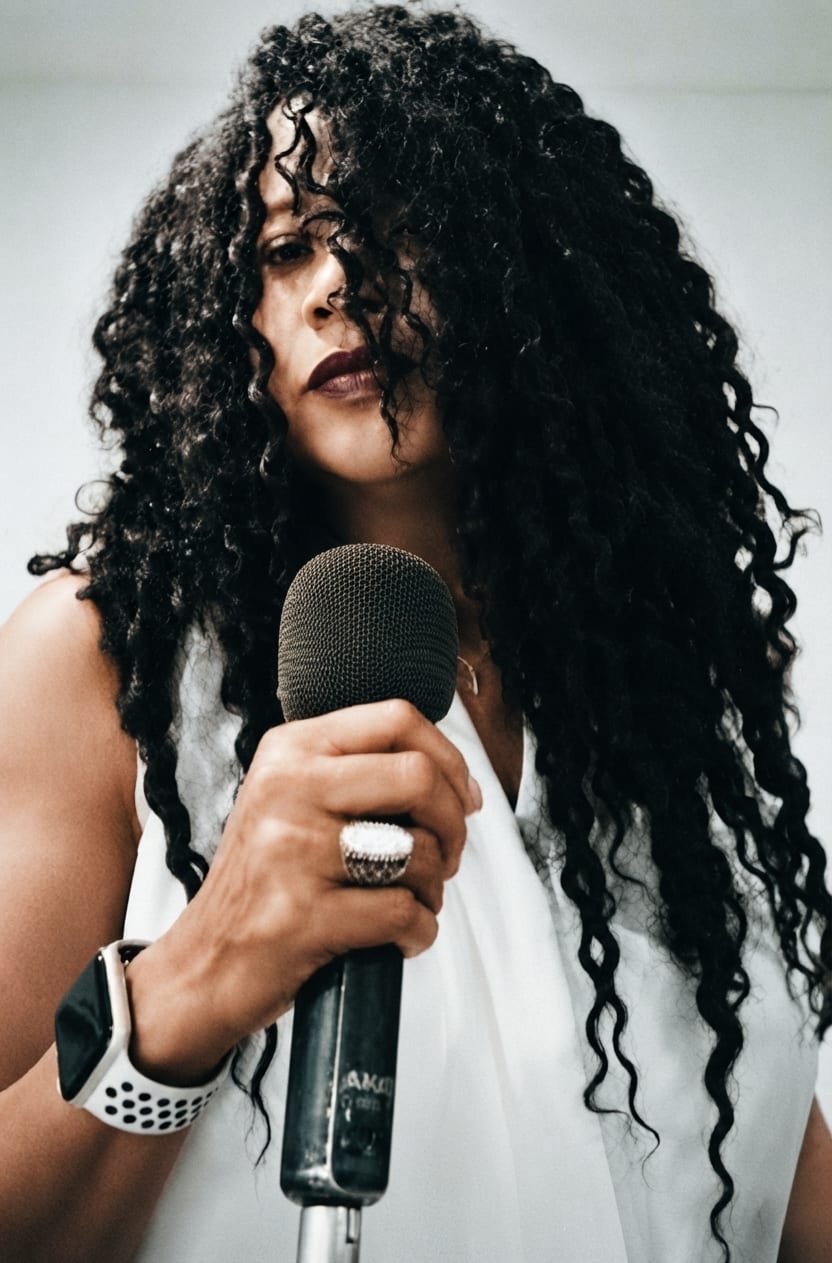 Traci Tota singing into a microphone